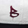 embossed red B print on the side of a cream cap