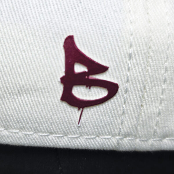 embossed red B print on the side of a cream cap