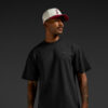 erson wearing a black MiB T‑shirt and a white and maroon MiB cap against a dark background.